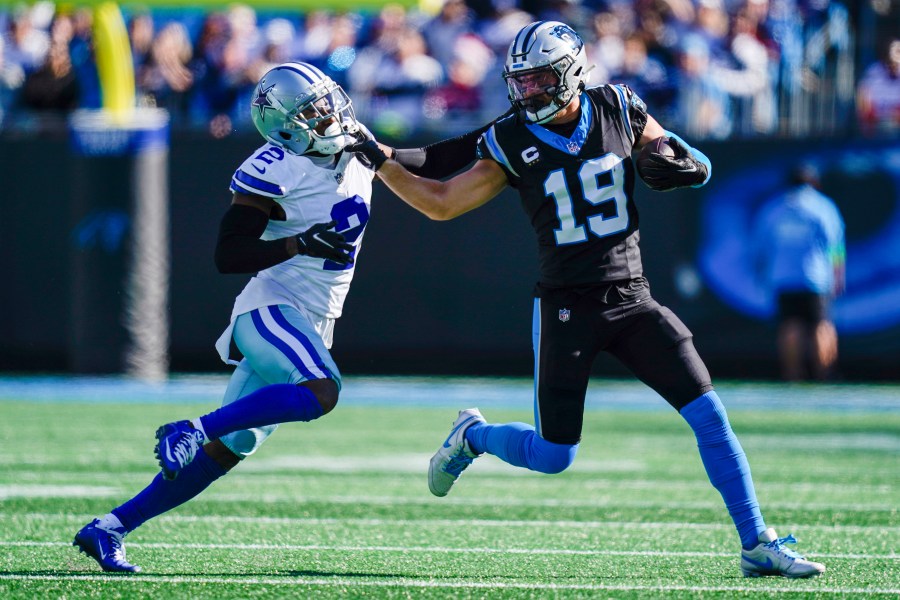 Carolina Panthers wide receiver Adam Thielen runs around Dallas Cowboys cornerback Jourdan Lewis during the first half of an NFL football game Sunday, Nov. 19, 2023, in Charlotte, N.C. (AP Photo/Erik Verduzco)